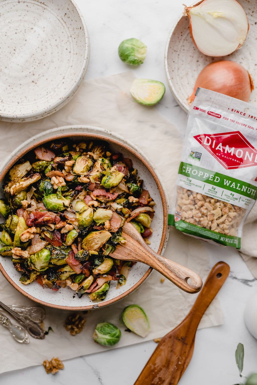 Bowl of Air Fryer Brussel Sprouts next to bag of Diamond chopped walnuts.