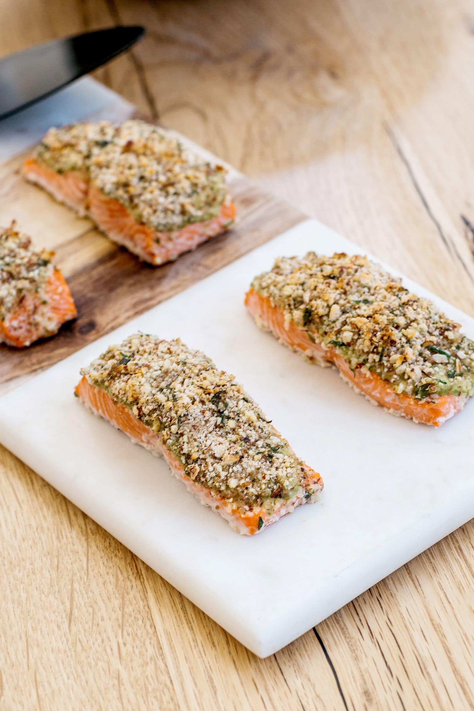 Cutting board with four pieces Almond Crusted Salmon.