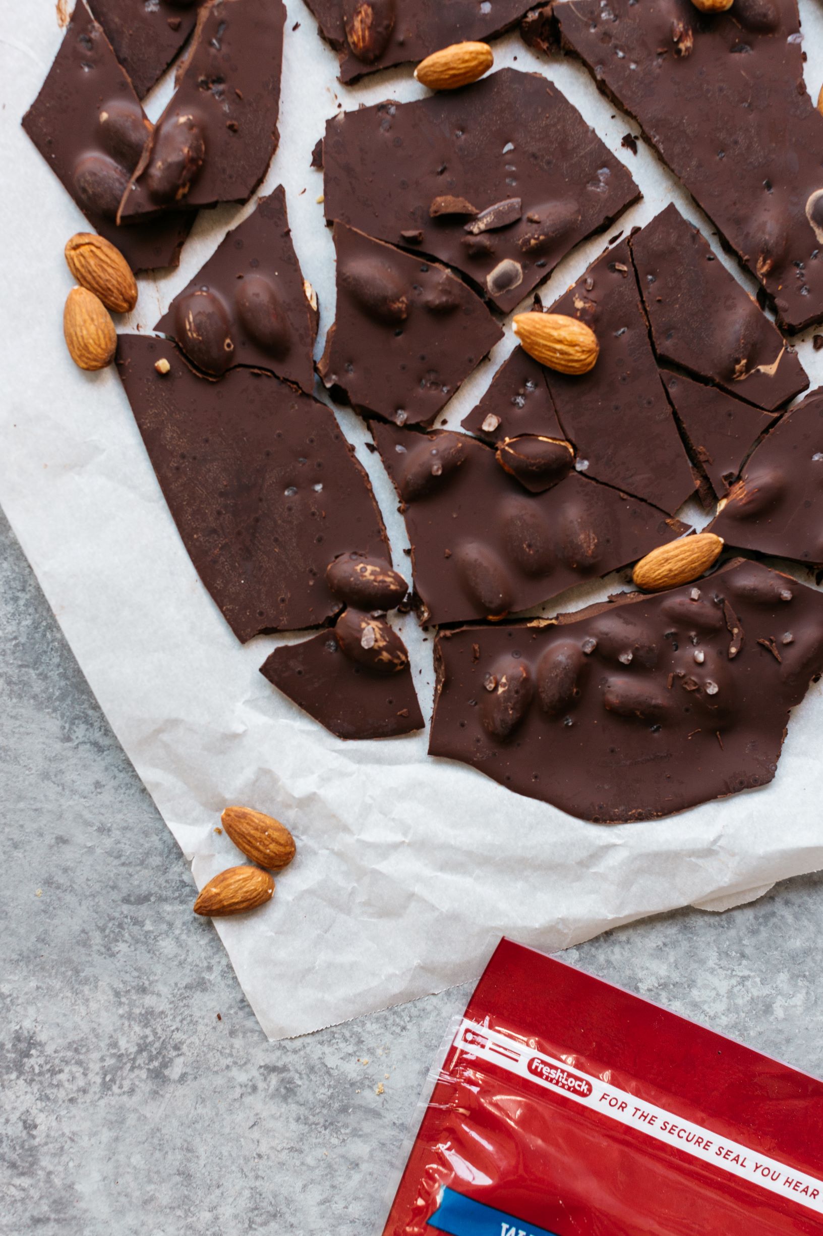 Wax paper with shards of Almond and Sea Salt Chocolate Bark.