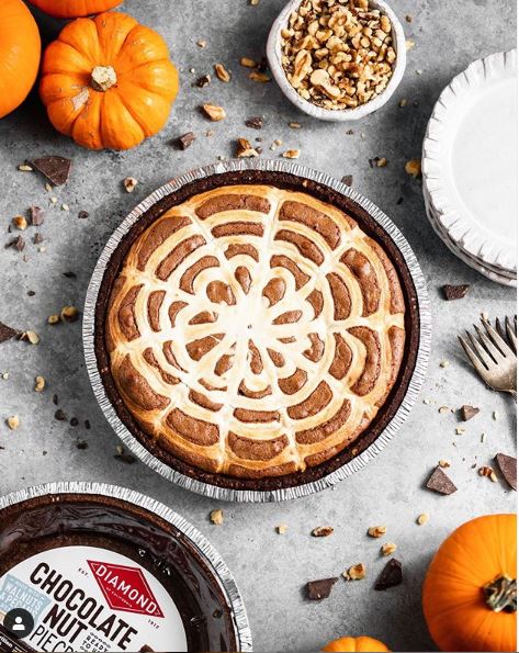 Halloween Brownie Pie next to decorative pumpkins and chocolate nut pie crust.