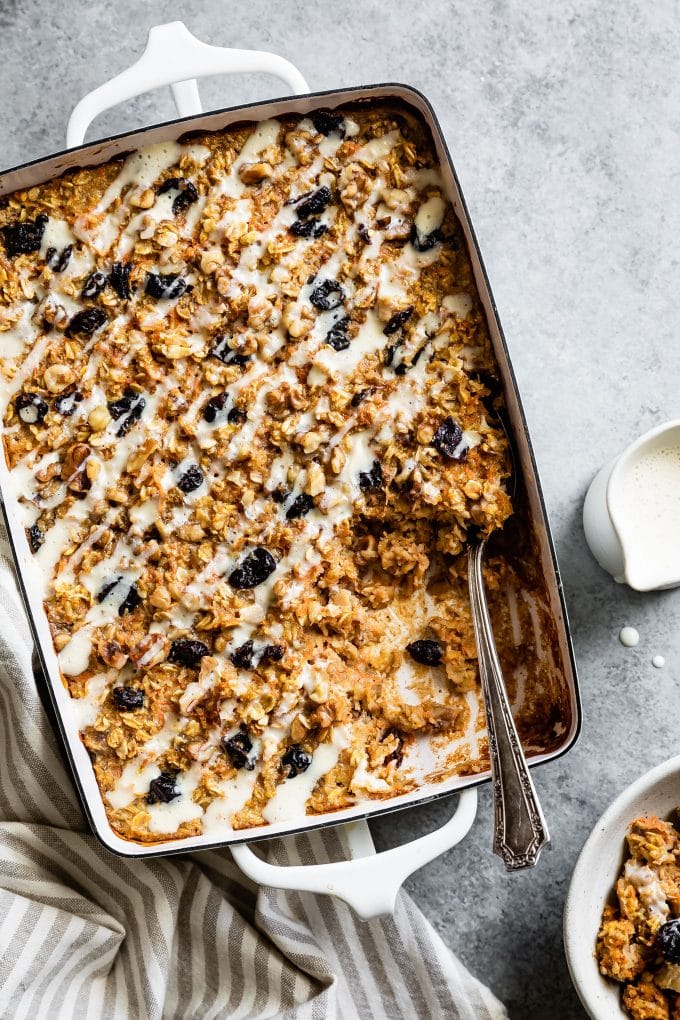 Casserole pan with Carrot Cake Baked Oatmeal drizzled with Maple Cream Cheese.