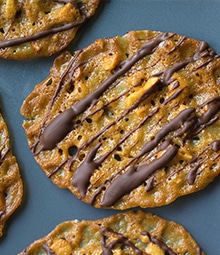 Cashew Lace Cookie drizzled with chocolate.