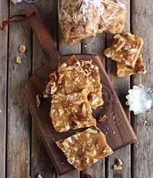 Cutting board with pieces of Salted Caramel Nut Brittle.