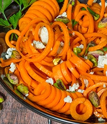 Bowl of Honey Carrot Salad with Pistachios and spiralized carrots.
