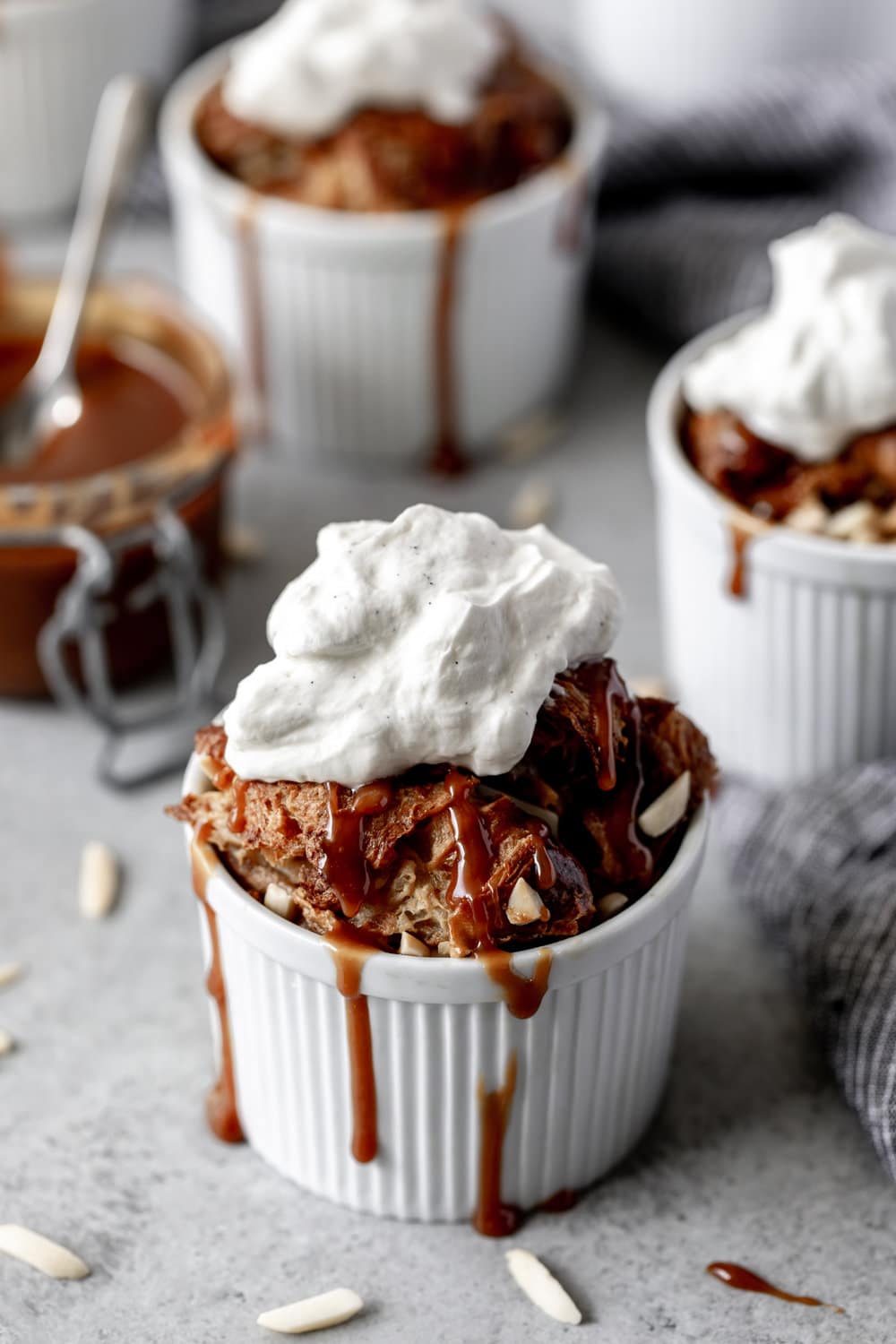 Individual Almond Croissant Bread Puddings with vanilla bean whipped cream and dripping caramel.