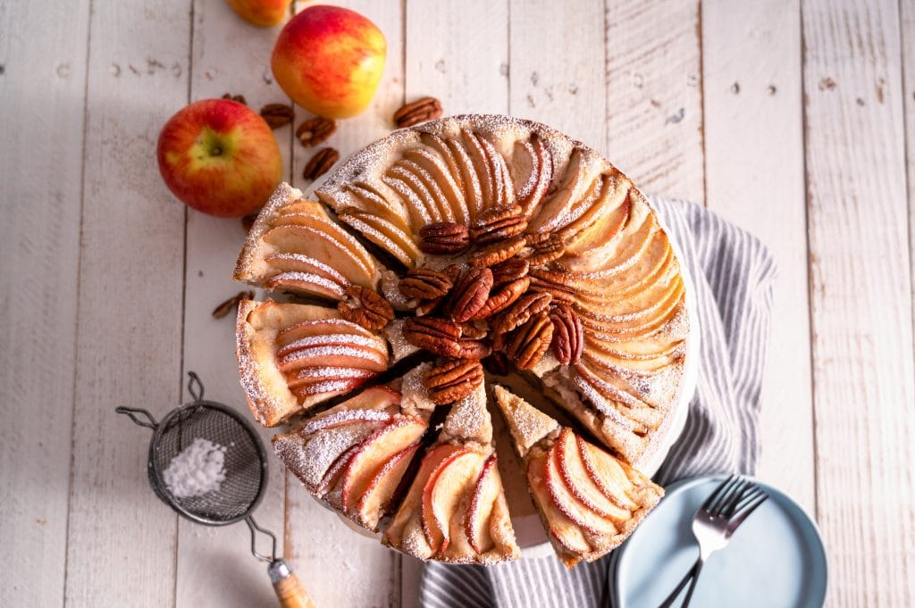 Sliced Apple Pecan Cake topped with powdered sugar.