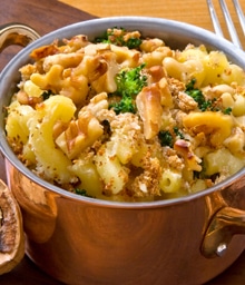 Big pot of macaroni and cheese with chopped nut topping.