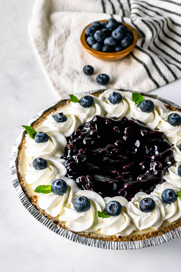 No-Bake Blueberry Cheesecake topped with whipped cream and fresh blueberries.