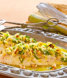 Plate of oven baked salmon topped with herbs and Diamond nuts.