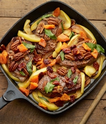 Cast iron pan with Pork Chops, Apples, and Pecans.