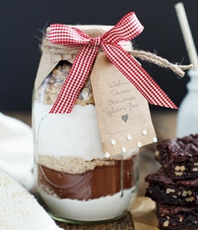 Mason jar gift layered with ingredients for Snixy Kitchen Walnut Cocoa Brownies.