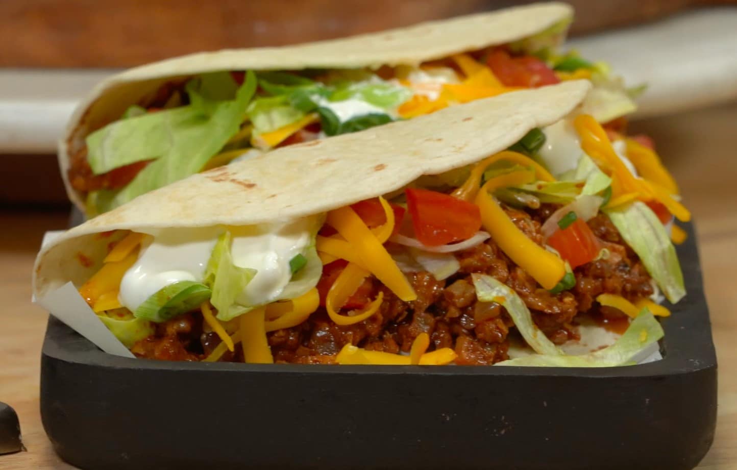 Plate of two soft tacos with Walnut Taco Filling and taco toppings.