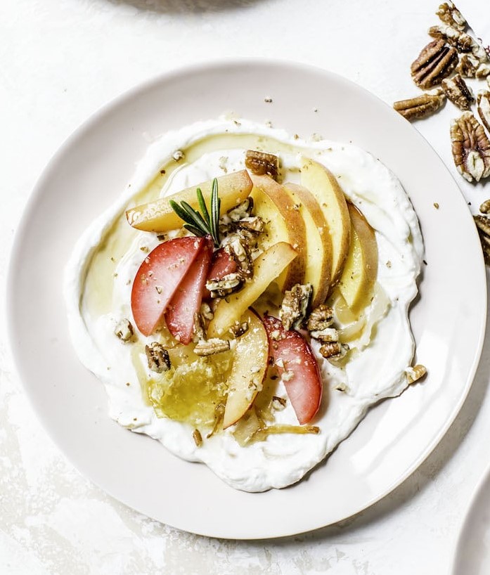 Yogurt Stone Fruit Salad topped with fruit, nuts, and herbs.