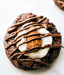 Almond Joy Thumbprint Cookie drizzled with chocolate.