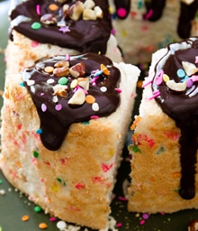 Angel Cake topped with chocolate frosting, colorful sprinkles, and nuts.