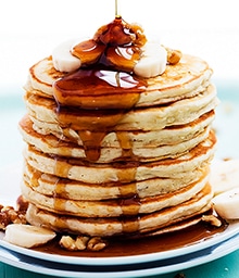 Stack of Banana Bread Pancakes with syrup and walnuts.