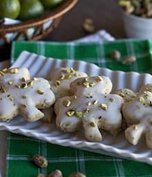 Plate of four leaf clover shaped Pistachio Key Lime Shortbread Cookies.