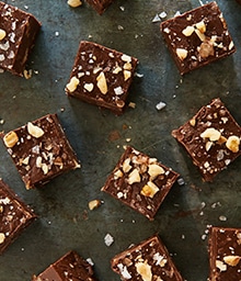 Several squares of Bittersweet Fudge topped with chopped Diamond Nuts.