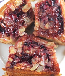 Three Blackberry Sticky Buns on a plate.