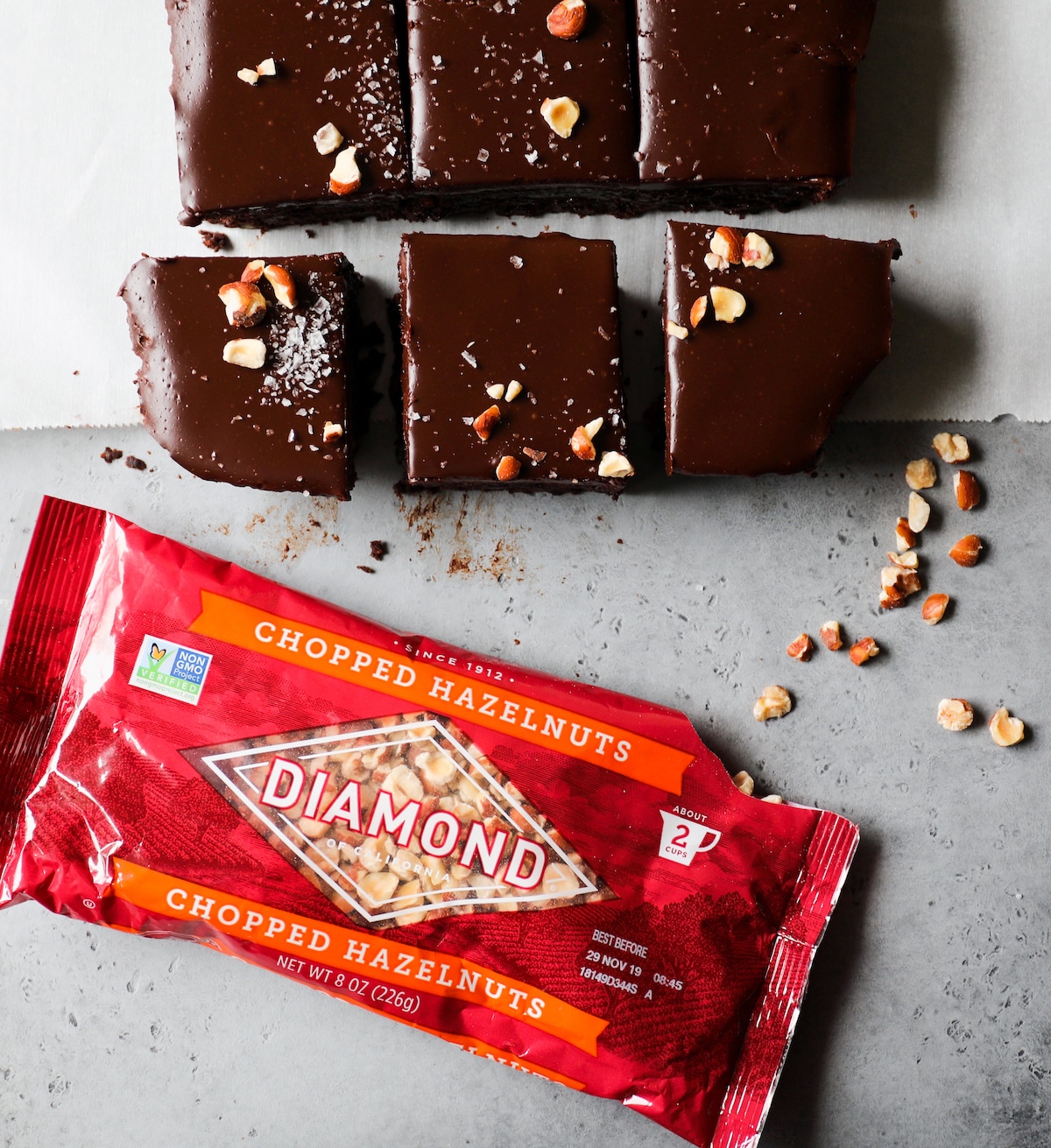 Chocolate Hazelnut Brownies with Coffee Ganache next to bag of Diamond hazelnuts.