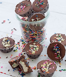 Cup overflowing with Cashew Cake Batter Cups with colorful sprinkles.