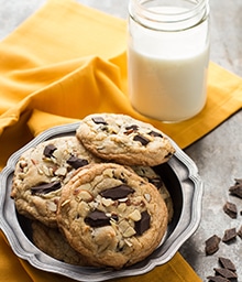 Plate of Cherry Almond Chocolate Chunk Cookies and glass of milk.