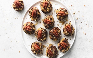 Plate of German Chocolate Cookie Balls topped with pecans.