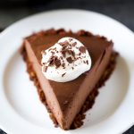 One slice of Triple Chocolate Cream Pie topped with whipped cream.