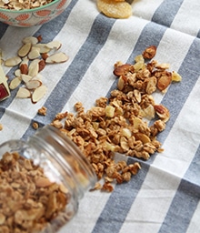 Coconut Ginger Almond Granola spilling out of mason jar.