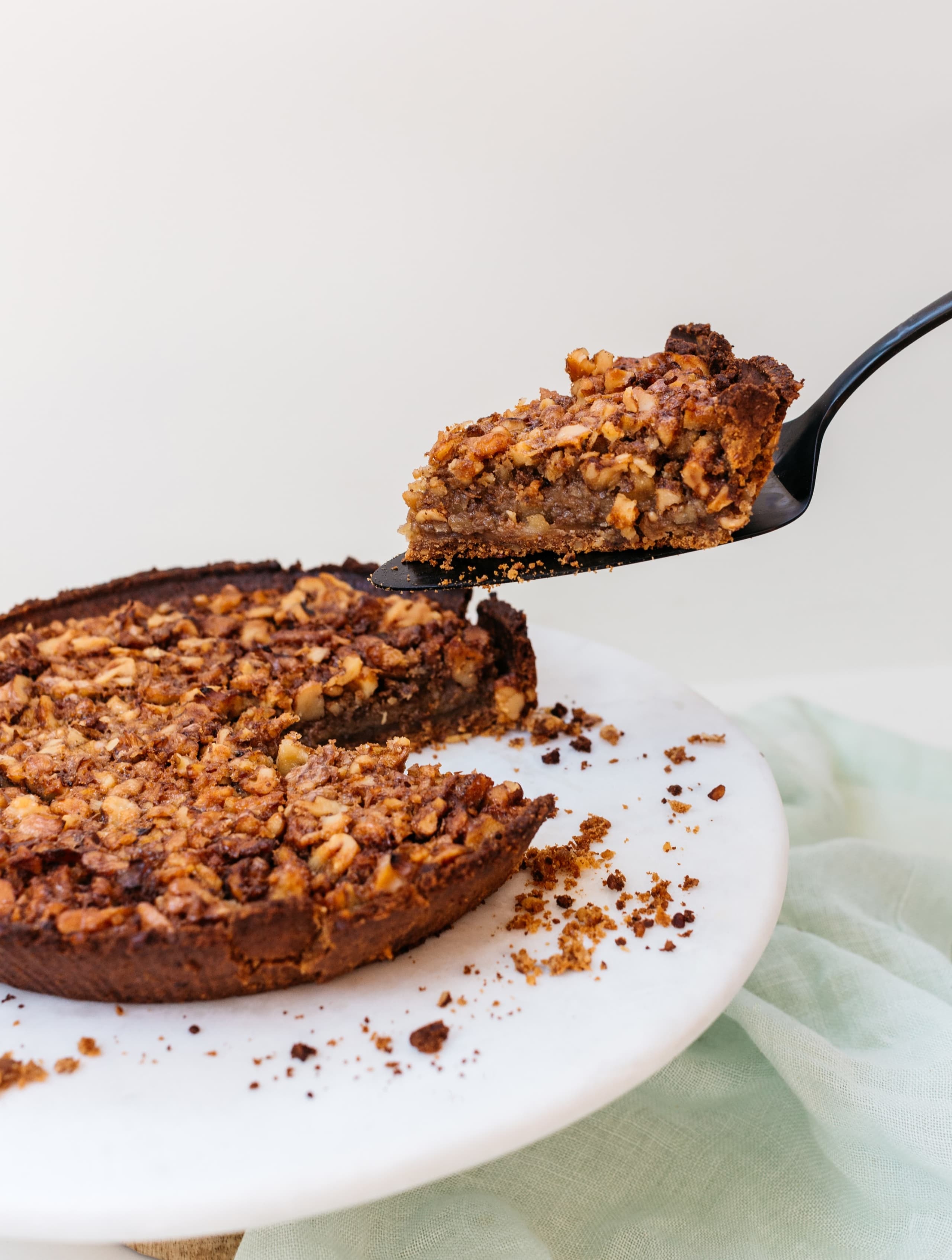 Person taking a slice out of Walnut Maple Pie with Diamond Walnut Pie Crust.