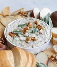 Gorgonzola and Walnut Dip with Sage surrounded by various dipping vessels.