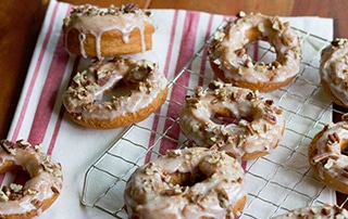 Spice Cake Donuts with Cinnamon Pecan Glaze on cooling rack.