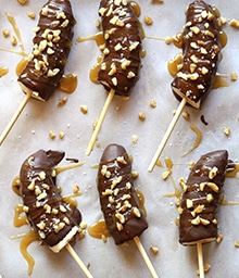 Two rows of Chocolate Covered Frozen Bananas with Caramel and Walnuts.