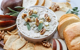 Gorgonzola and Walnut Dip with Sage surrounded by various dipping vessels.