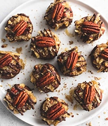Plate of German Chocolate Cookie Balls topped with pecans.