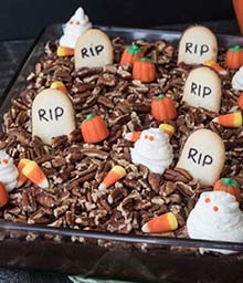 Halloween Graveyard Cake with gravestone, pumpkin, and ghost decorations.