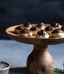 Raised wooden display plate with Chocolate Dipped Hazelnut Sandies.