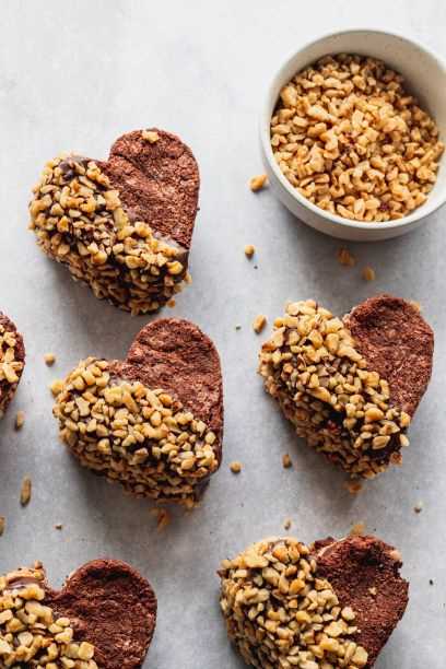 Several Brownie Cookie Dough Hearts half-coated in nuts.
