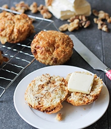 Halved Honey Walnut and Brie Biscuit with pat of butter.