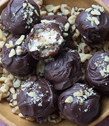 Plate of Maple Walnut Truffles, one with bite taken out.