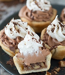 Mini Chocolate Silk Pecan Pie Bite cut in half topped with whipped cream.