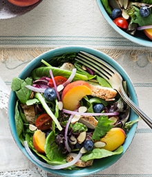 Bowl of Grilled Chicken and Peach Salad with Diamond sliced almonds.