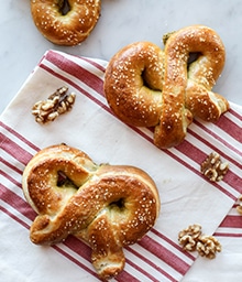 Cheese and Pesto Filled Soft Pretzels and walnuts on counter.