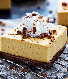 Pumpkin Cheesecake Bar with Gingersnap Crust topped with whipped cream.