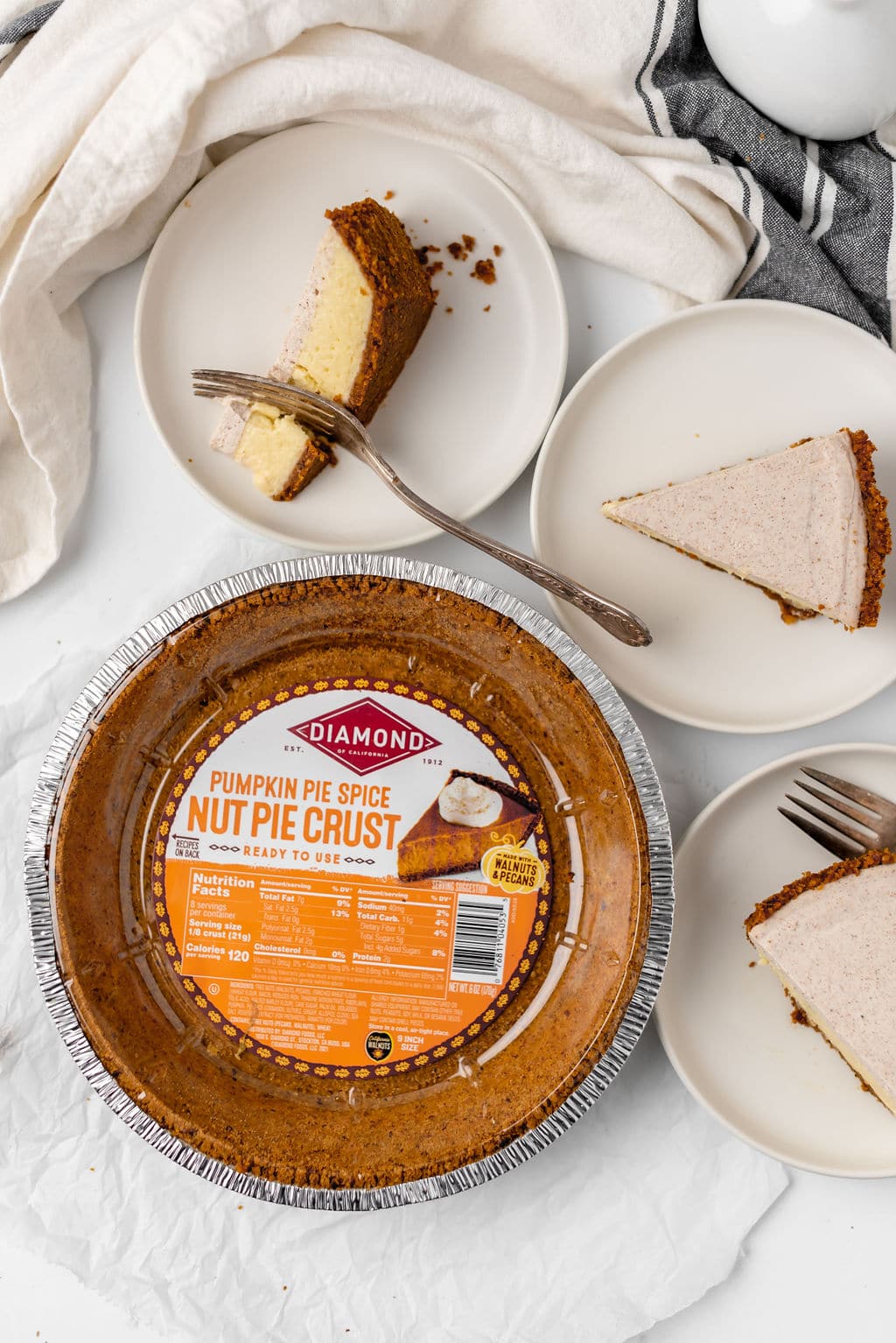 Pumpkin pie spice nut pie crust and slices of cheesecake.