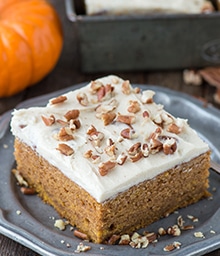 Slice of Pumpkin Cake with Butter Pecan Frosting and chopped pecans.