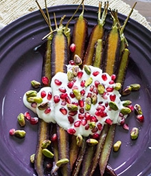 Plate of rustic Roasted Carrots with festively colorful Pistachio Feta Sauce.
