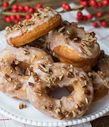 Plate of stacked Spice Cake Donuts with Cinnamon Pecan Glaze.