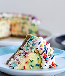 Slice of Sprinkle Cheesecake with Walnut Crust.