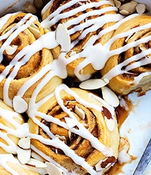 Flaky Almond Cinnamon Buns drizzled with icing.